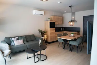 a living room with a couch and a table at Camping Natuurlijk Limburg - Appartement in Voeren