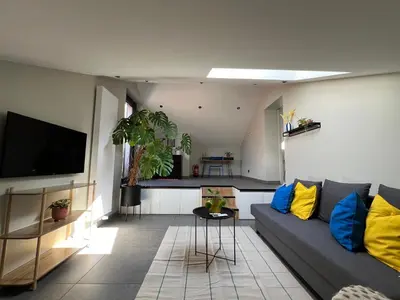 a living room with a couch and a tv at Studio SC - Cozy appartement in Genk near Thor Park - 4 people in Genk