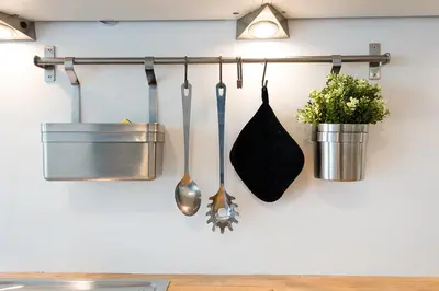 a kitchen with utensils hanging on a wall at La petite Naimette in Liège