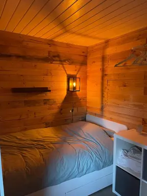 a bedroom with a bed in a wooden wall at La Luna in Lanaken
