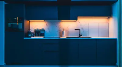 a kitchen with dark blue cabinets and a sink at Suite Ôna in Bassenge