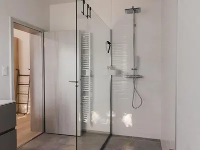 a bathroom with a shower with a glass door at Le Surdan in Bassenge