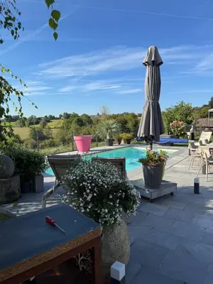 a patio with a pool and an umbrella and a table at Studio 94 in Welkenraedt