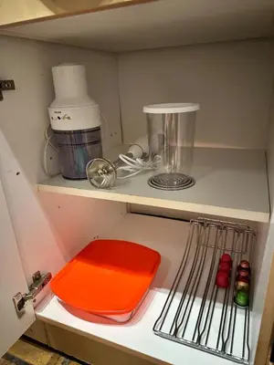 a kitchen shelf with a red plate and utensils at Studio 94 in Welkenraedt