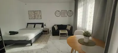 a bedroom with a bed and a couch and a table at Studio spacieux ,chaleureux et cosy in Heers