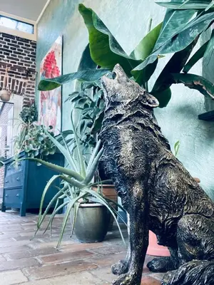 a statue of a bear standing next to a potted plant at Het Wolvennest in Maasmechelen