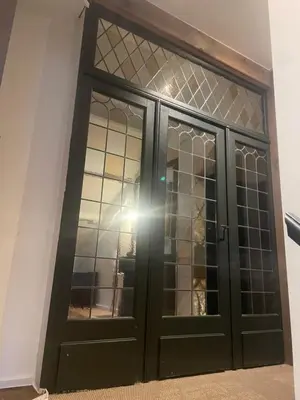 a black door with glass windows in a room at Het Wolvennest in Maasmechelen