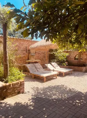 a patio with two benches and an umbrella at Het Wolvennest in Maasmechelen