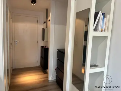 a hallway with a mirror and a dresser in a room at Le studio de la Cathédrale - Hypercentre avec balcon in Liège