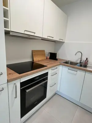 a kitchen with white cabinets and a sink and a stove at Le Cabinet in Liège