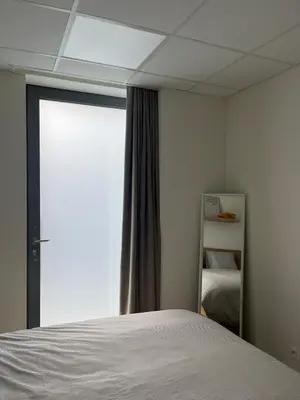 a bedroom with a bed and a large window at Le Cabinet in Liège
