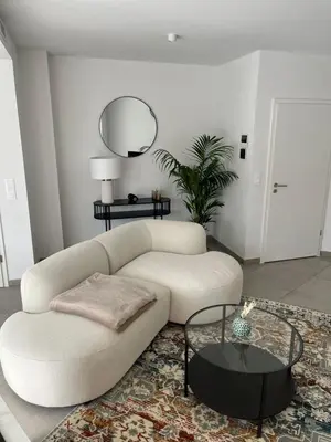 a living room with a white couch and a table at Appart lumineux avec terrasse au cœur de Liège in Liège