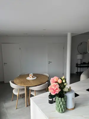 a dining room with a table and flowers on a table at Appart lumineux avec terrasse au cœur de Liège in Liège