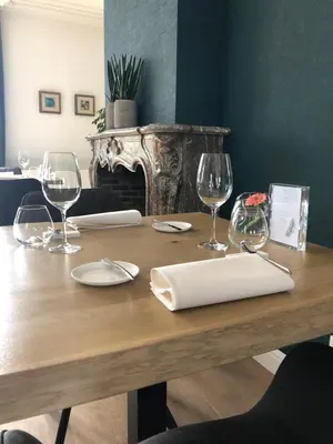 a wooden table with wine glasses and a napkin at Charme logies Kampernoelie in Hoeselt