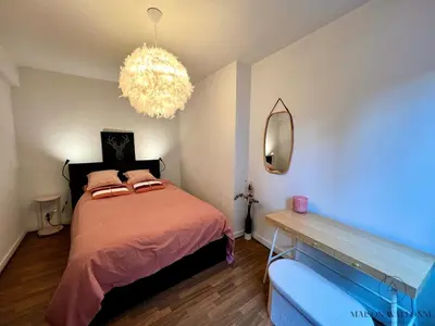 a bedroom with a bed and a chandelier at Le Léopold - Cocon en Hypercentre de Liège in Liège