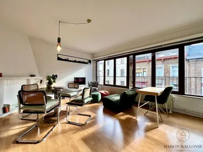 a living room with chairs and a table and windows at Le Léopold - Cocon en Hypercentre de Liège in Liège