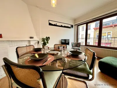a dining room with a glass table and chairs at Le Léopold - Cocon en Hypercentre de Liège in Liège
