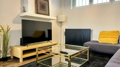 a living room with a large flat screen tv at Aux Cèdres - Peaceful stay with easy parking in Liège