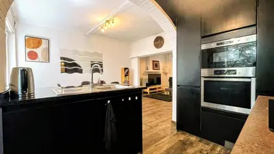 a kitchen with a sink and a stove top oven at Aux Cèdres - Peaceful stay with easy parking in Liège