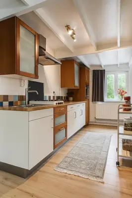 a kitchen with white cabinets and a sink at Zenda's natuurhuisje in Lanaken
