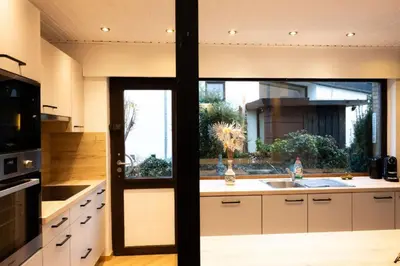 a kitchen with a sink and a large window at Maison modernisée au caractère 70ies in Herstal