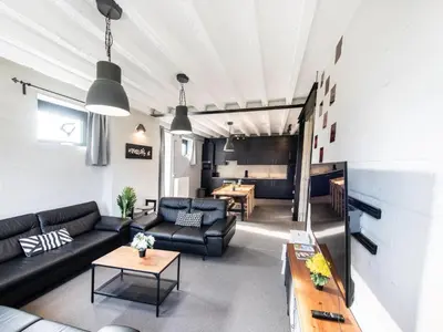 a living room with a couch and a table at Farmhouse with garden and wellness in Heers