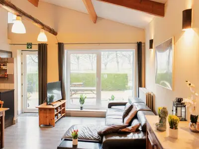 a living room with a couch and a large window at Cozy duplex apartment with terrace in Heers