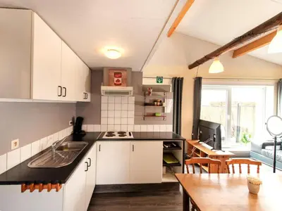 a kitchen with white cabinets and a dining room at Cozy duplex apartment with terrace in Heers