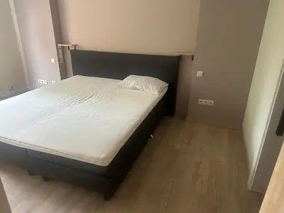 a small bedroom with a bed with white sheets at Residentie Ons Genoegen in Lommel