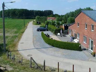 a street with a car parked next to a brick building at Apartment with a view of alpacas in Heers