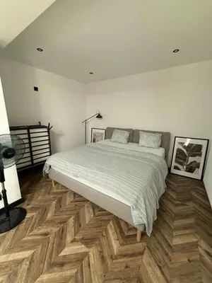 a bedroom with a large bed and wooden floors at Premium apartment at the gates of Liège in Liège