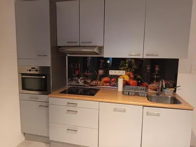 a kitchen with white cabinets and a wooden counter top at Badoumkassa & Mbanga in Welkenraedt