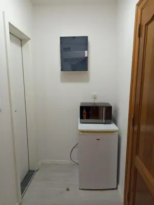 a kitchen with a microwave on top of a refrigerator at Badoumkassa & Mbanga in Welkenraedt