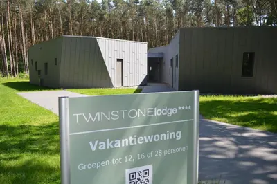 a building with a sign in front of it at Twinstone Lodge in Genk