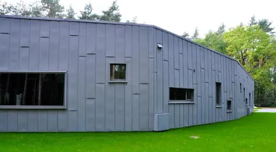 a gray building with windows on the side of it at Twinstone Lodge in Genk