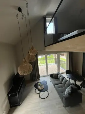 a living room with a couch and a table at Camping Natuurlijk Limburg - appartement 2p in Voeren