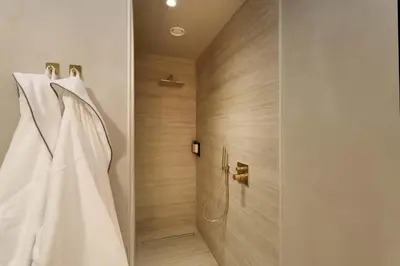 a wedding dress hangs in a shower in a bathroom at Woodz Lodges - Unwind in nature in Heusden - Zolder