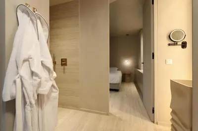 a bathroom with a white robe hanging on a wall at Woodz Lodges - Unwind in nature in Heusden - Zolder