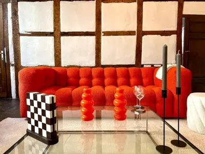 a living room with a red couch and a glass table at Clémentine - 3 chambres en Hypercentre in Liège