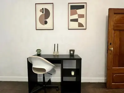 a black desk with a white chair in a room at Clémentine - 3 chambres en Hypercentre in Liège