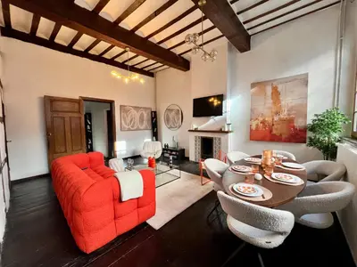 a living room with a red couch and a table at Clémentine - 3 chambres en Hypercentre in Liège