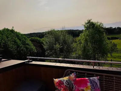 a balcony with a view of a field and trees at Tiny House Dreiländereck in La Calamine