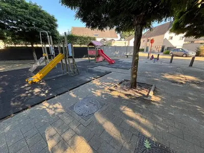 a playground with a yellow slide next to a tree at Modern, child-friendly country house