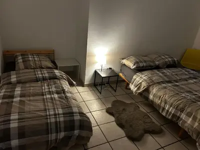 a bedroom with two beds and a lamp on a tiled floor at Grâce à Liège in Grâce-Hollogne