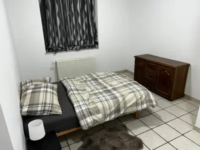 a small bedroom with a bed and a dresser at Grâce à Liège in Grâce-Hollogne