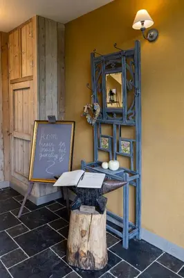 a room with a table and a chalkboard and a shelf at B&B Kamer en Aambeeld in Zoutleeuw