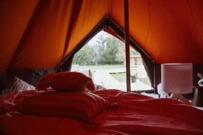 a bedroom with a bed in a tent at Glamping Chateau d'Hamont in Herk-de-Stad