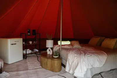 a bedroom with a bed in a red tent at Glamping Chateau d'Hamont in Herk-de-Stad