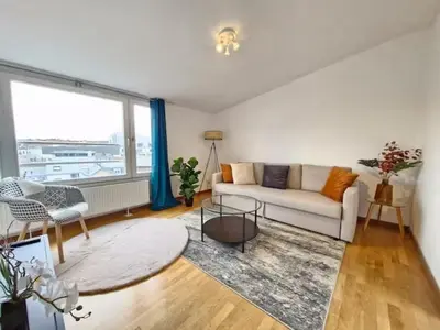 a living room with a white couch and a large window at Cocon Liégeois in Liège
