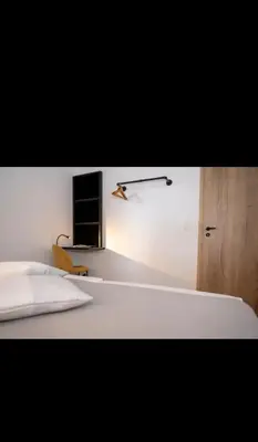 a bedroom with a bed and a tv on a wall at Le Marzelheide 1 in Lontzen